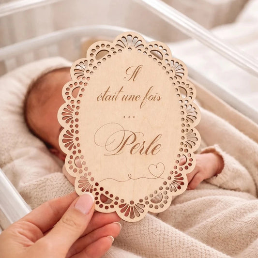 Carte de naissance en bois gravé forme ovale pour annoncer la naissance d’un bébé.