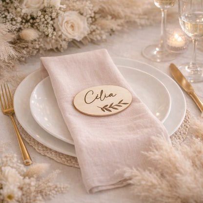 Marque-place en bois personnalisé 7x4 cm avec prénom en écriture calligraphique et motif feuillage. Idéal pour mariage et événement.